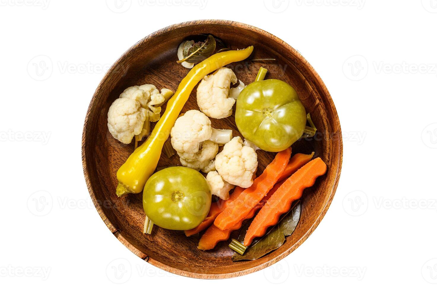 Salted and pickles vegetables preserve in a wooden plate. Isolated, white background. Top view. photo
