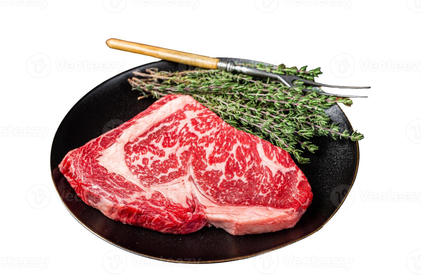 Black Angus Rib Eye steak, raw marbled beef meat with herbs. Isolated on white background. Top view. photo