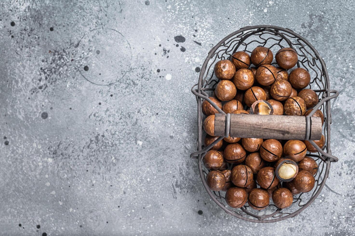 Macadamia organic nuts in a basket. Gray background. Top view. Copy space photo