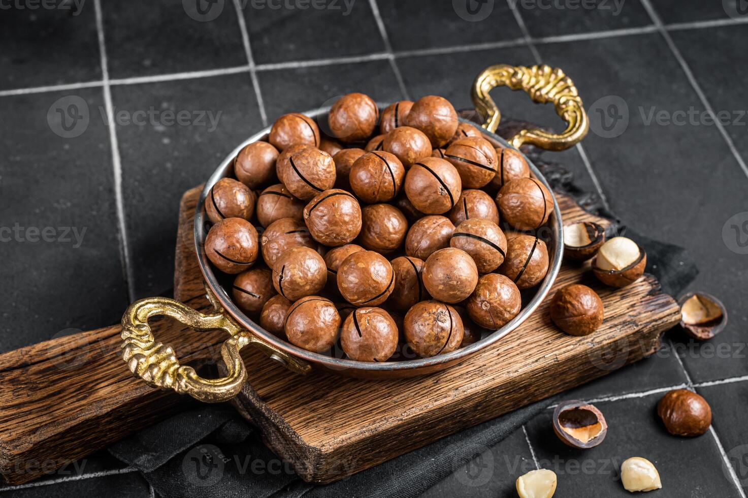 Macadamia nuts in a shell ready to eat. Black background. Top view photo