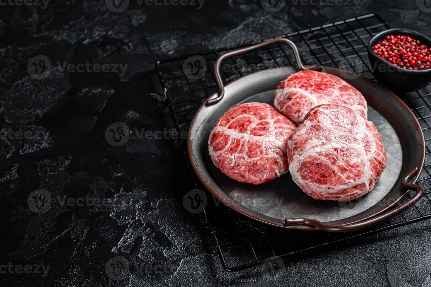 Raw pork cutlet, Crepinette with spices and herbs. Black background. Top view. Copy space photo