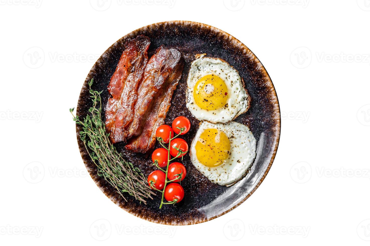 Breakfast with fried eggs and bacon with herbs in plate. Isolated, white background. Top view. photo