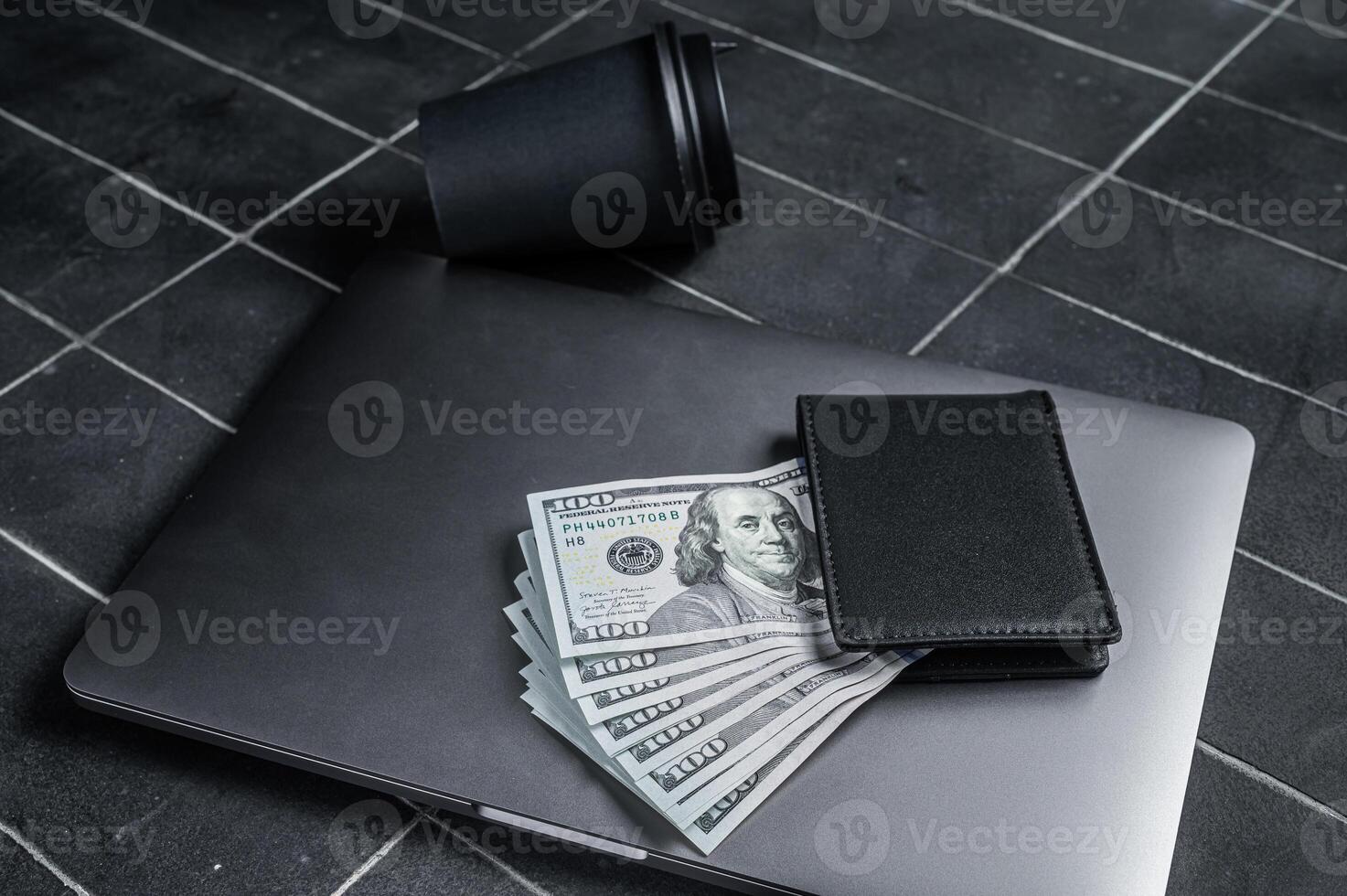Corporate business desktop with laptop, digital tablet, wallet, money and cup of coffee. Black background. Top view. Copy space photo