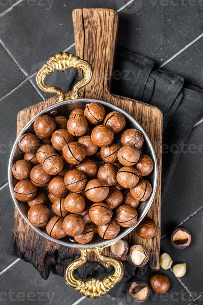 Macadamia nuts in a shell ready to eat. Black background. Top view photo