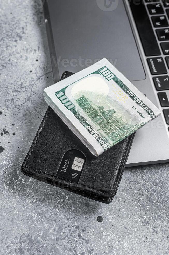 Workplace with stylish leather wallet with money, Laptop. Gray background. Top view. Copy space photo