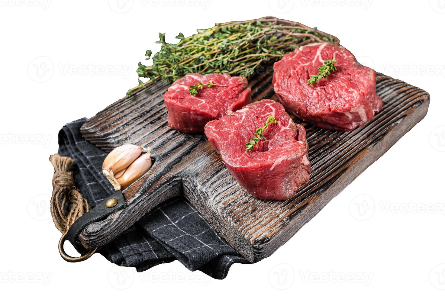Prime raw Fillet mignon steaks on a wooden board with thyme and garlic. Isolated on white background, top view. photo