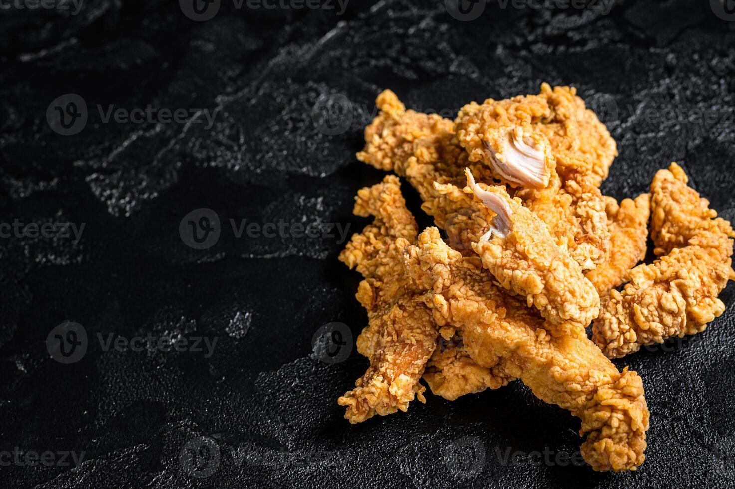 Breaded chicken strips Fingers, breaded breast meat. Black background. Top view. Copy space photo