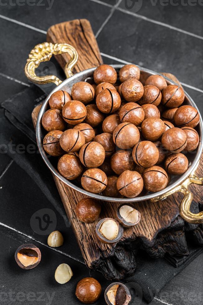 Macadamia nuts in a shell ready to eat. Black background. Top view photo