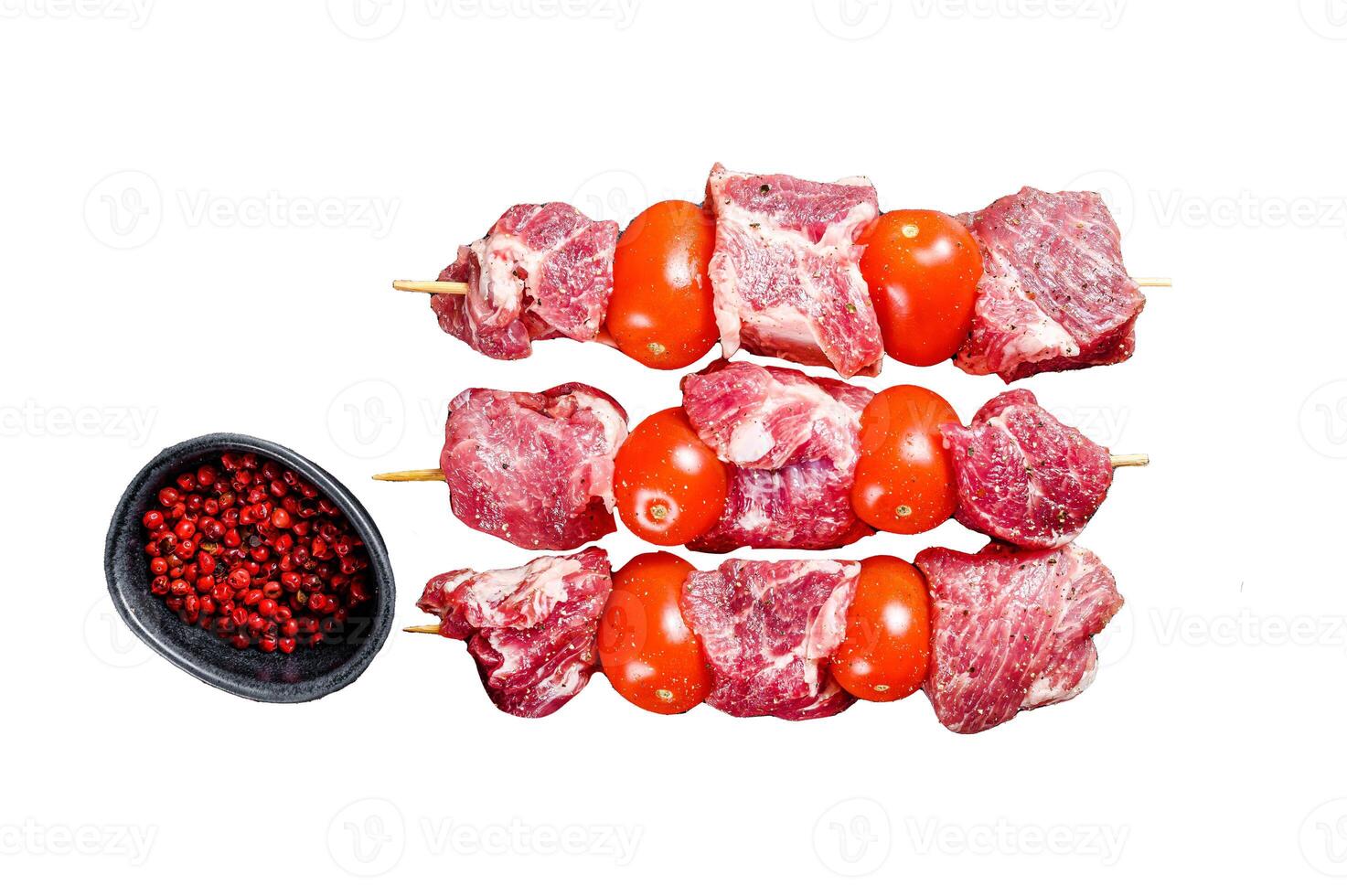 Raw beef meat kebab. BBQ with tomato and spices. Isolated on white background. Top view. photo