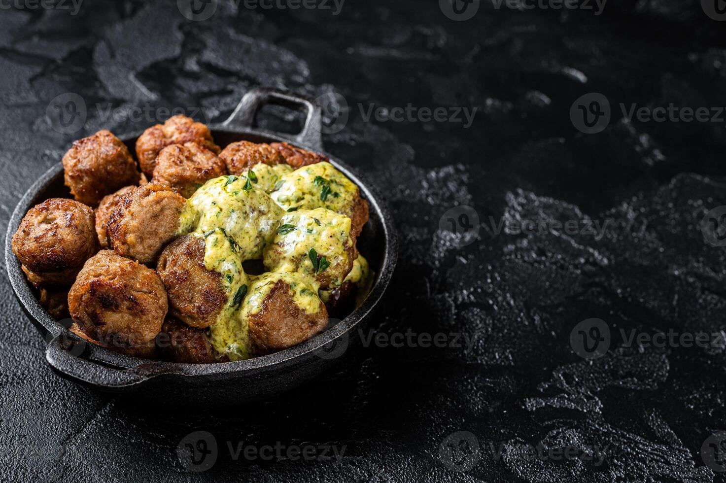 Skillet with Swedish beef Meatballs with Cream Sauce. Black background. Top view. Copy space photo