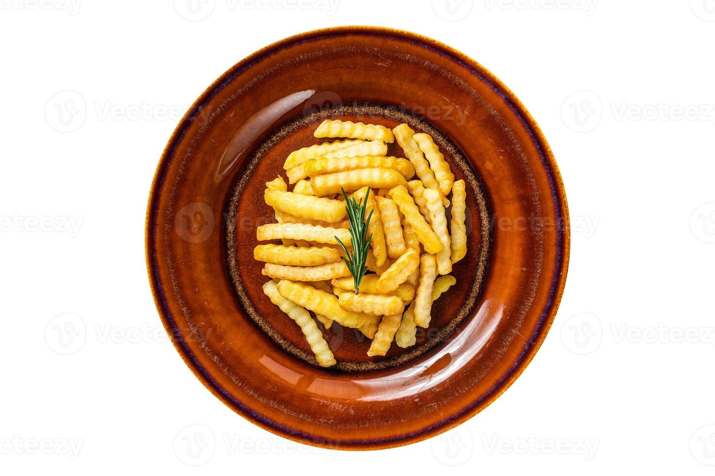 Fried Crinkle French fries potatoes or chips in a rustic plate. Isolated, white background. Top view. photo