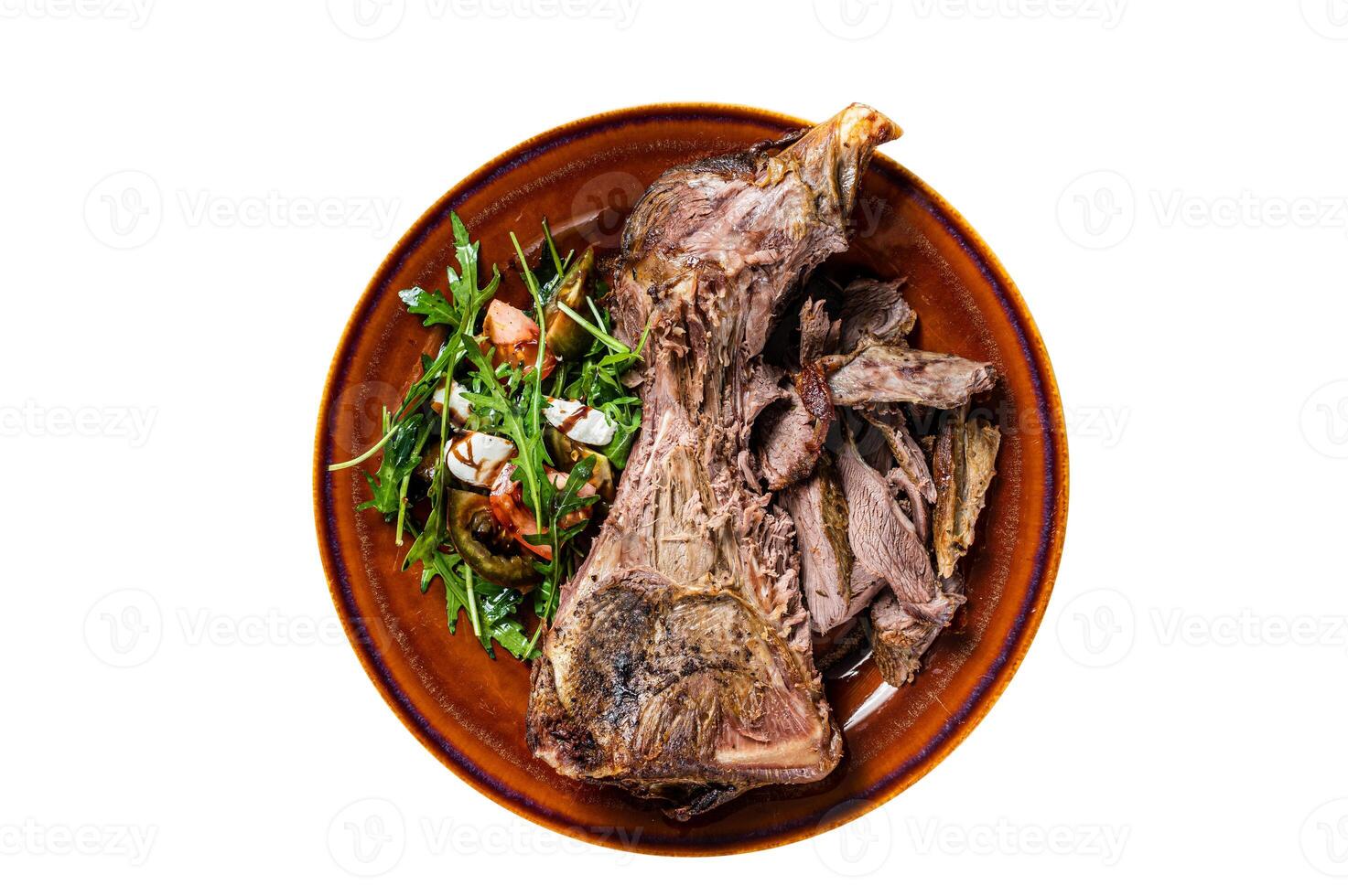 Grilled goat or lamb mutton shoulder meat in a rustic plate with salad. Isolated, white background. Top view. photo