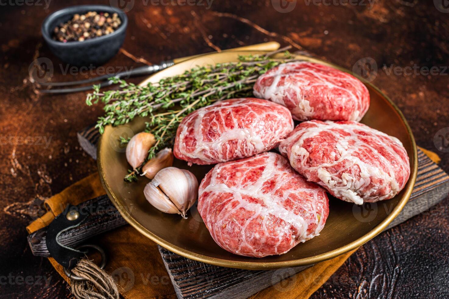 Raw french meatballs cutlet with spices and herbs. Dark background. Top view photo