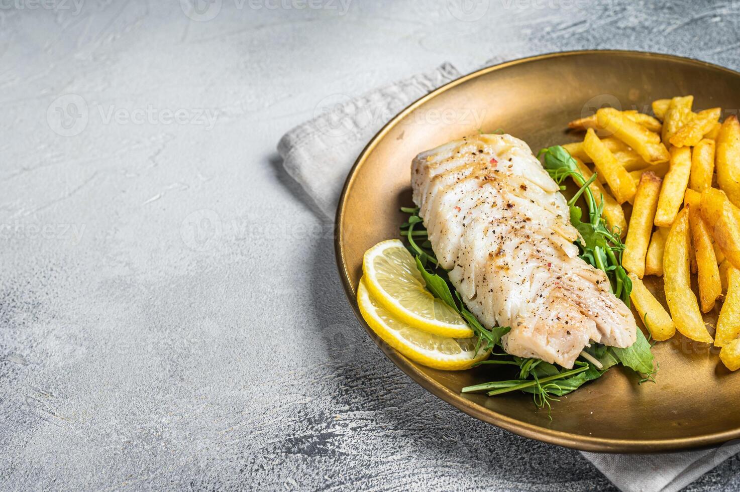 Fried cod fish fillet served with french fries. White background. Top view. Copy space photo