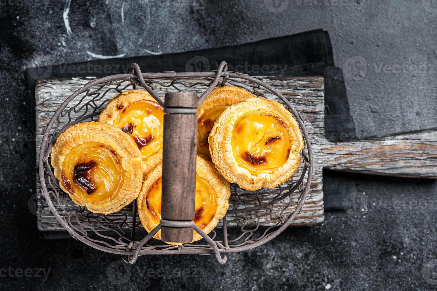 Traditional Lisbon Pasteis de nata in a basket. Black background. Top view photo