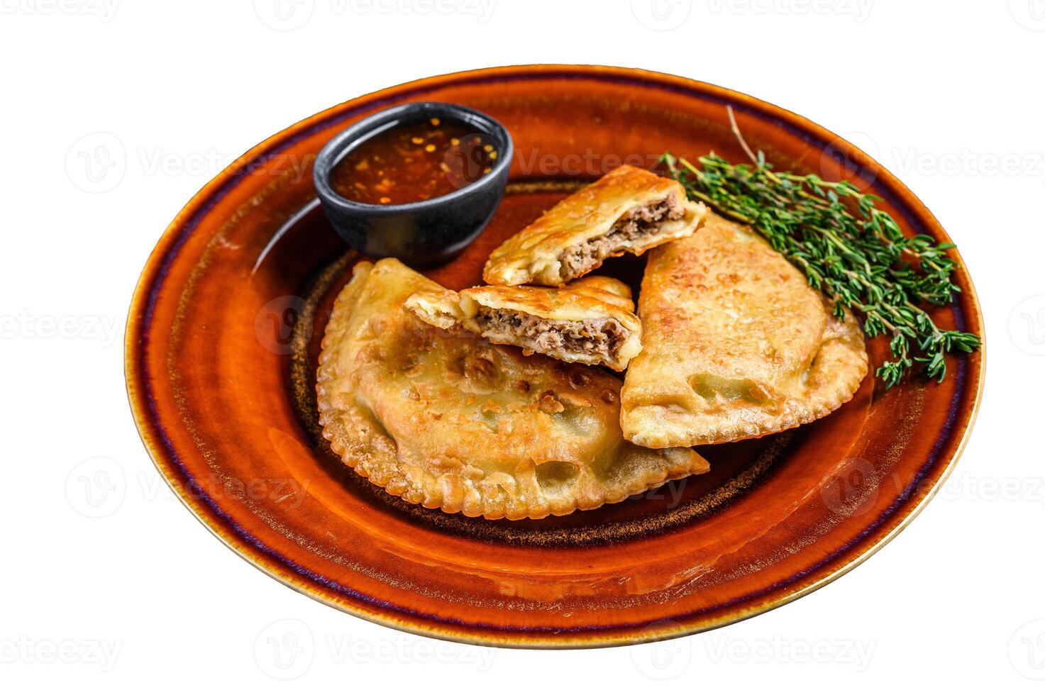Fried empanadas with minced beef meat served on a plate with chili sauce. Isolated on white background. photo