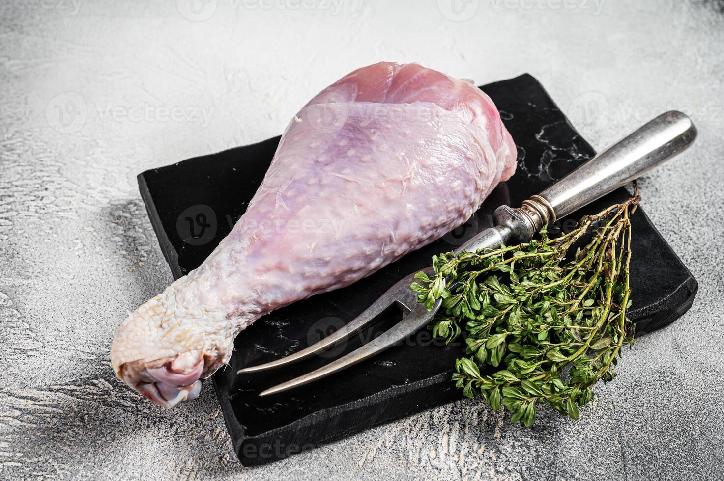 Raw turkey leg thigh with thyme and spices. White background. Top view photo