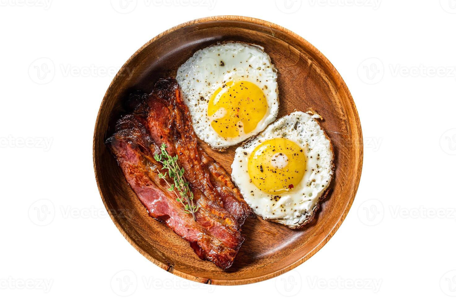Traditional English breakfast with fried eggs and bacon in wooden plate. Isolated, white background. Top view. photo