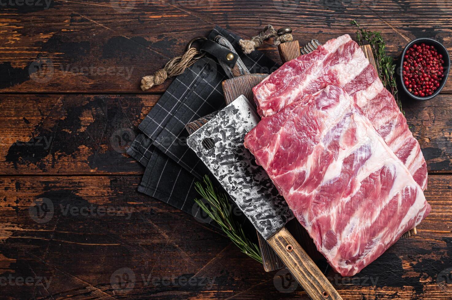Butcher board with rack of raw pork spare ribs. Wooden background. Top view. Copy space photo
