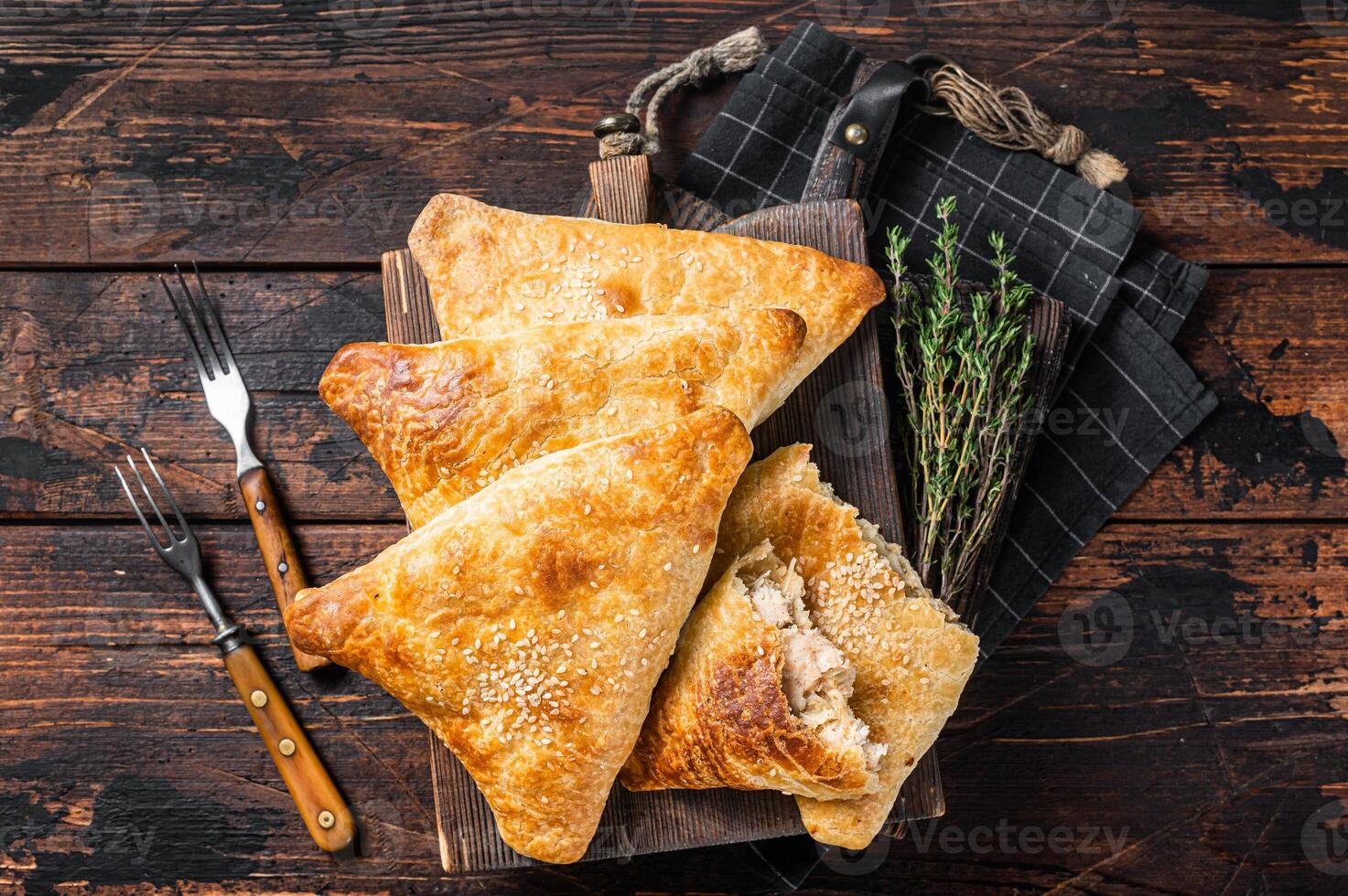 Baked samosa with chicken and cheese, samsa pies. Wooden background. Top view photo