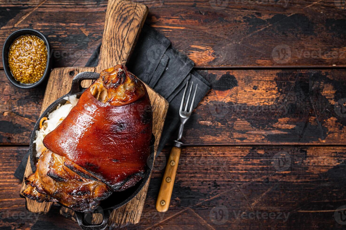 Bavarian Schweinshaxe Roast pork Hock Ham, knuckle with Sauerkraut. Wooden background. Top view. Copy space photo
