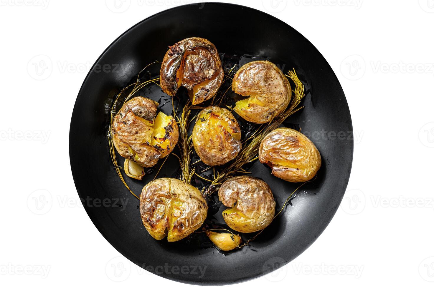 Jacket baked potato with garlic and rosemary in a plate. Organic vegetables. Isolated on white background. photo