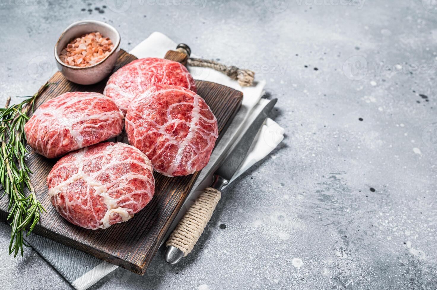 Raw Caul Fat Meatballs burger cutlets, fresh meat. Gray background. Top view. Copy space photo