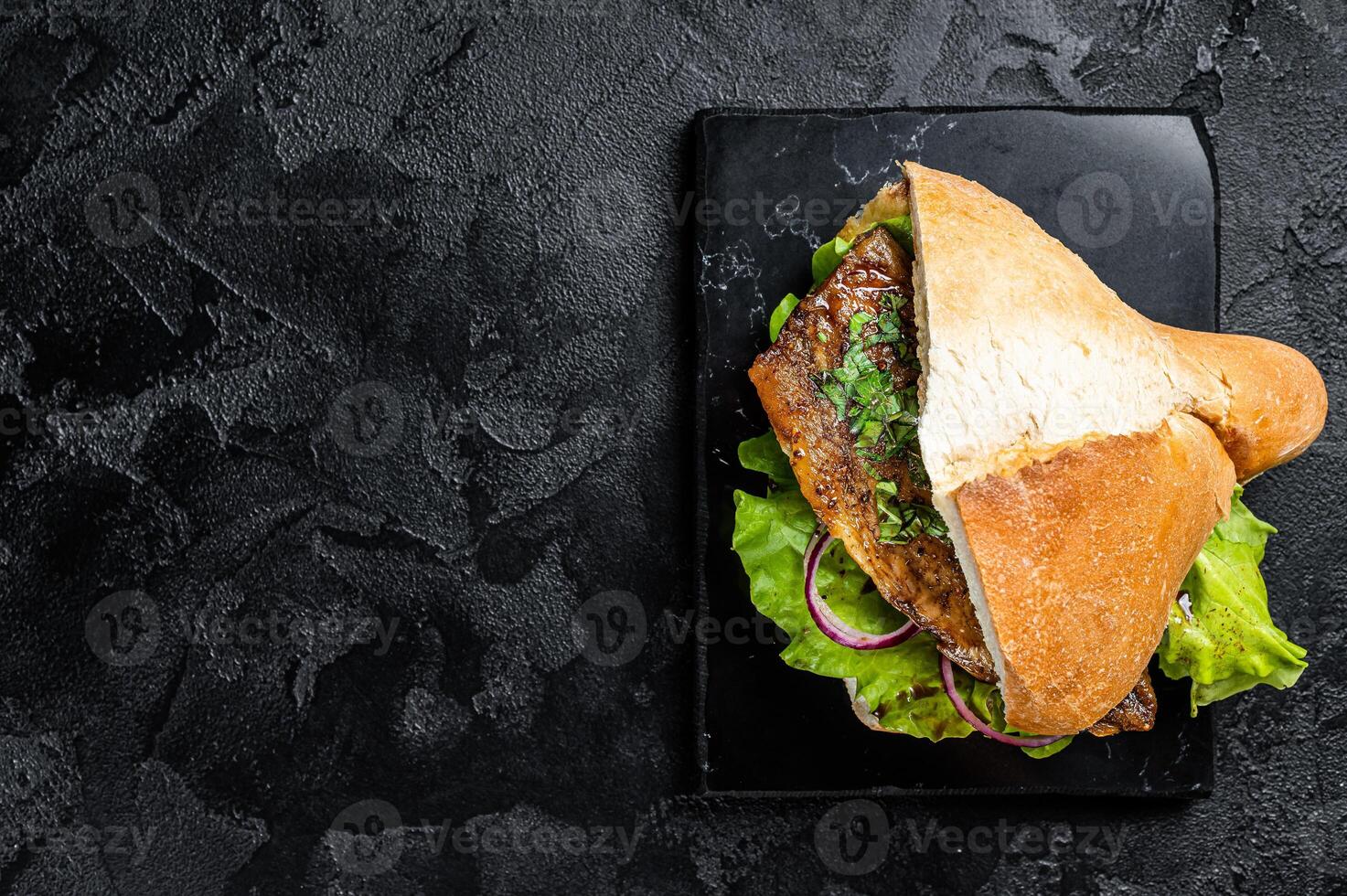 Turkish fish sandwich with grilled mackerel fillet Balik Ekmek. Black background. Top view. Copy space photo