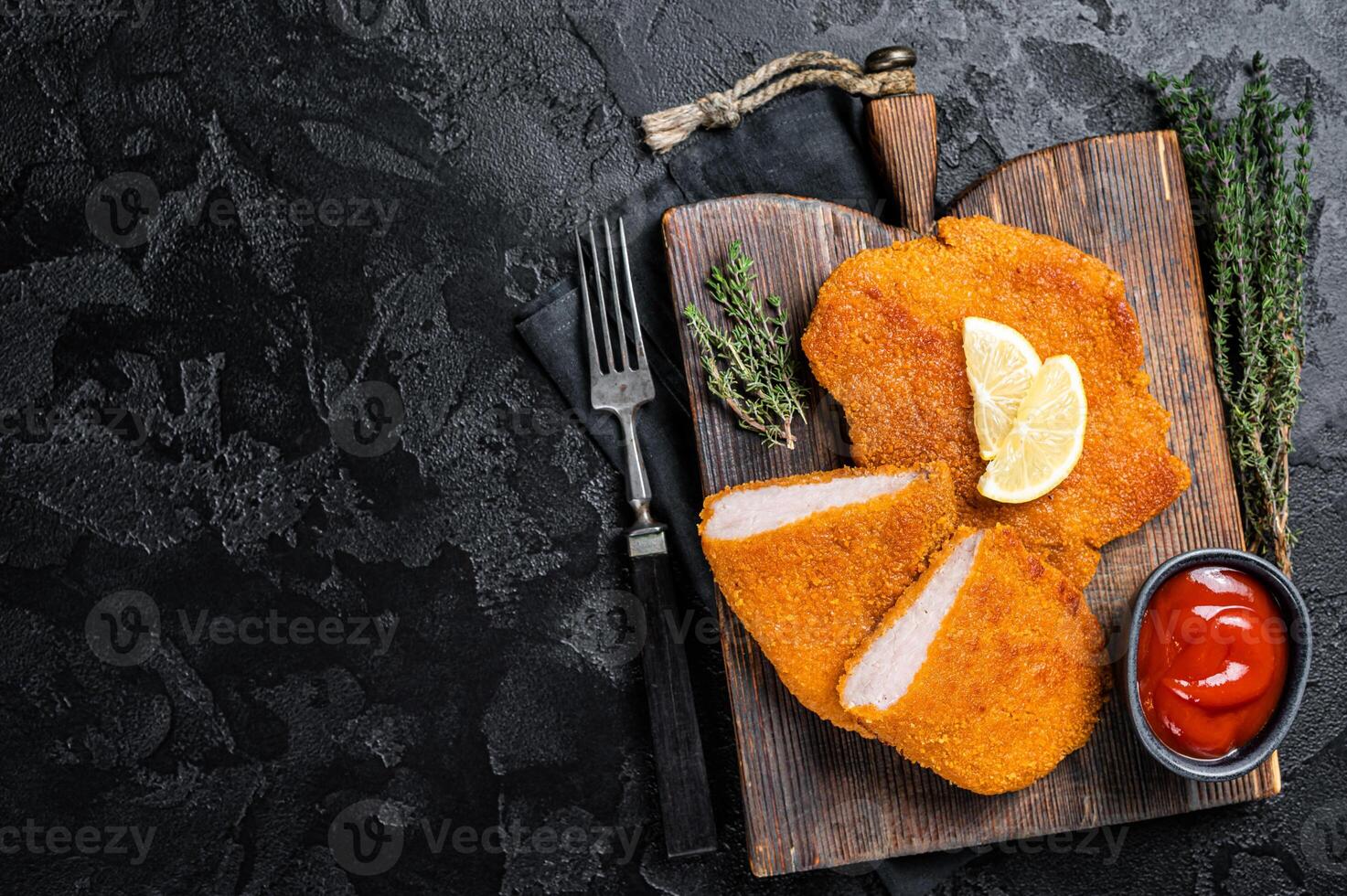 Viennese veal escalope, fried meat Schnitzel steak. Black background. Top view. Copy space photo