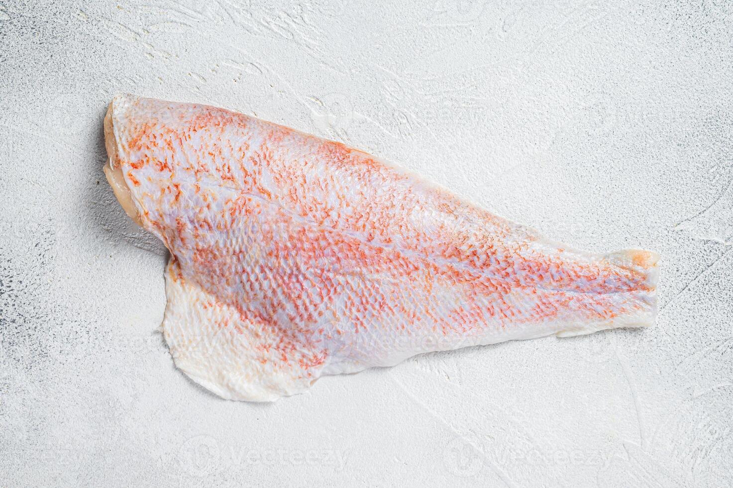 Raw red perch fillet, redfish fish meat. White background. Top view. Copy space photo