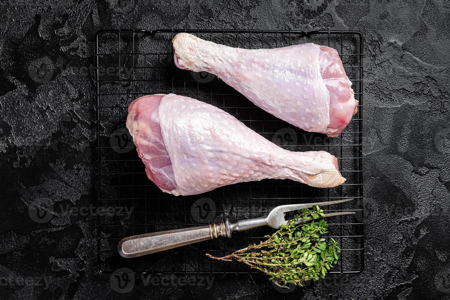 Raw turkey legs on a butcher table. Black background. Top view photo
