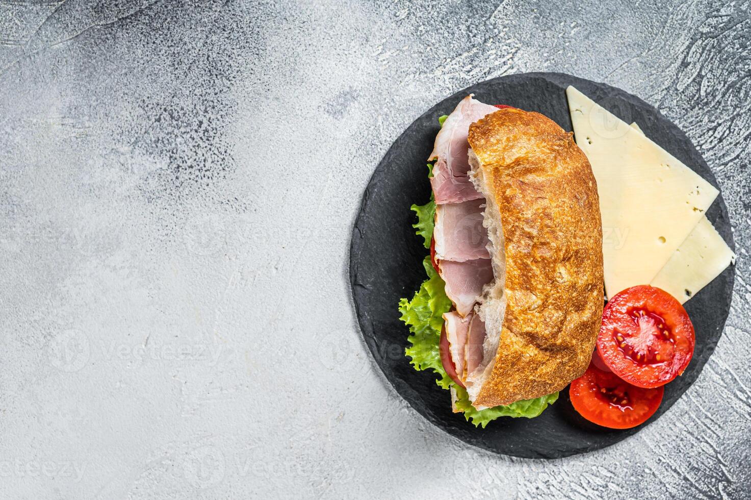 Fresh and healthy turkey sandwich with white cheese, tomato and Lettuce in white bread. White background. Top view. Copy space photo