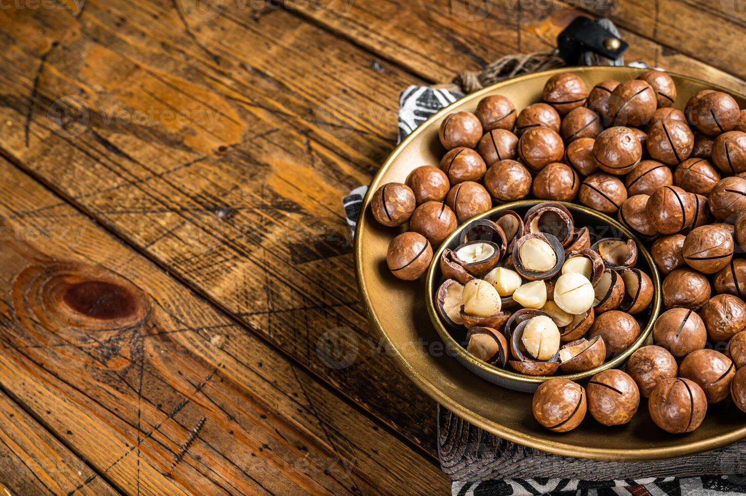 Organic Macadamia nuts in a shell ready to eat. Wooden background. Top view. Copy space photo