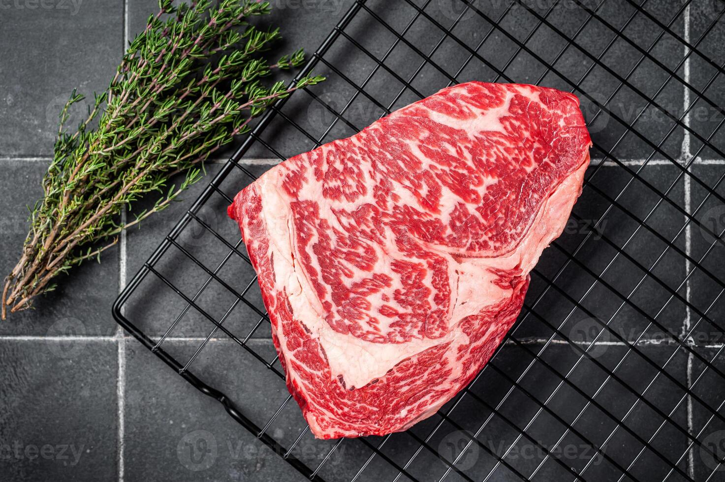 Uncooked wagyu Rib Eye steak, raw beef meat. Black background. Top view photo