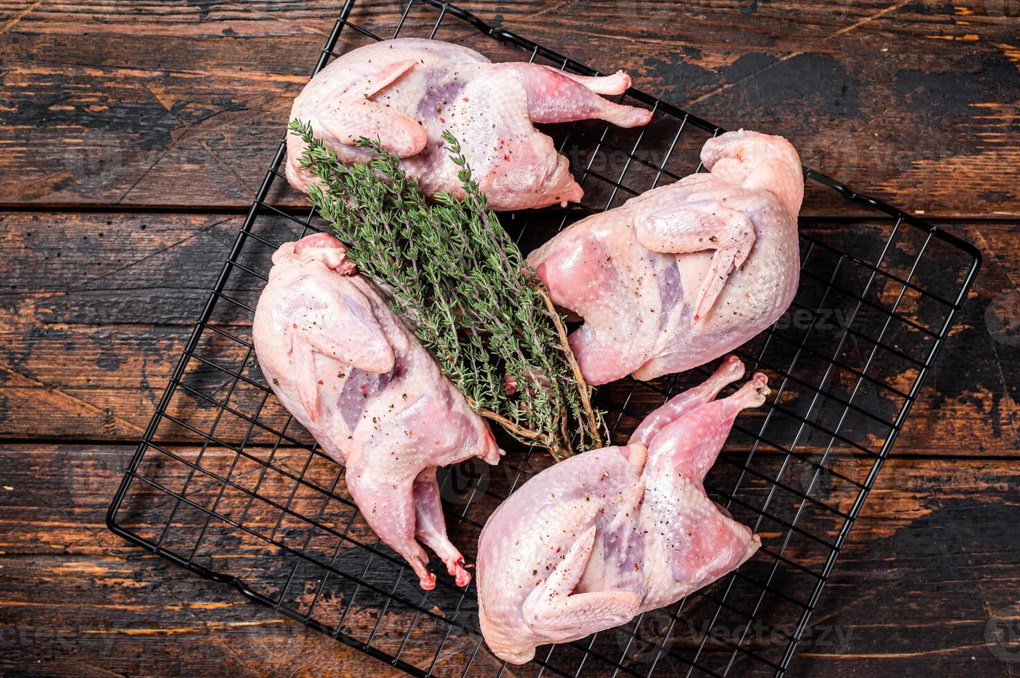Farm eco friendly raw quails on kitchen table. Wooden background. Top view photo