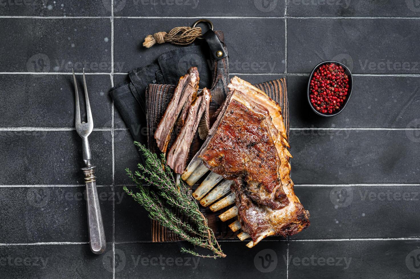 Grilled Rack of lamb ribs, mutton spareribs on wooden board. Black background. Top view photo