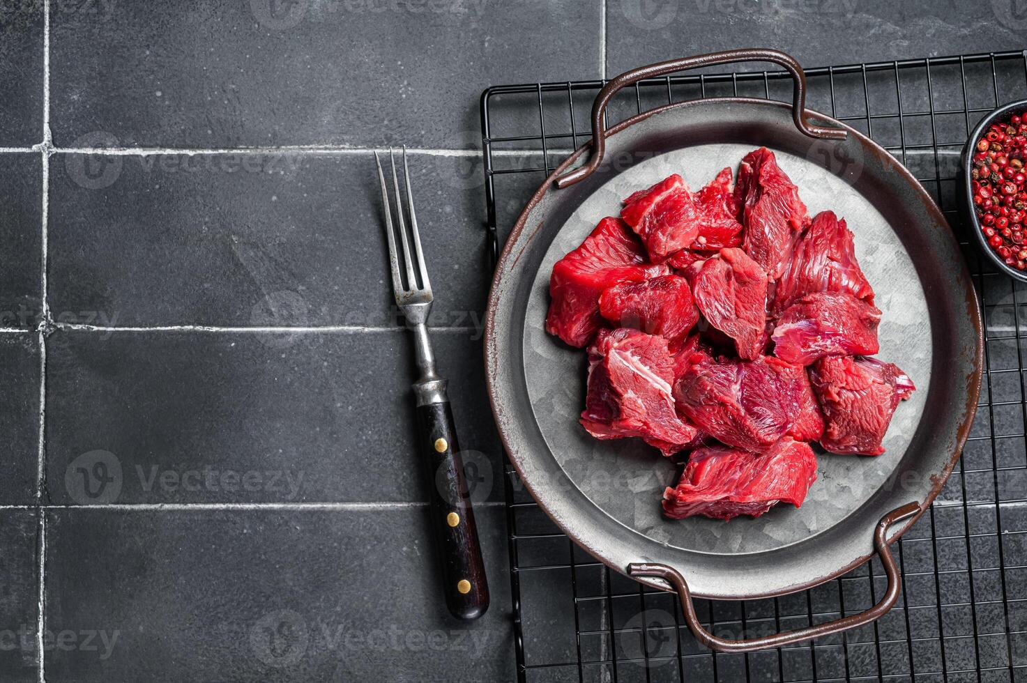 Pieces of raw diced beef fillet meat. Black background. Top view. Copy space photo