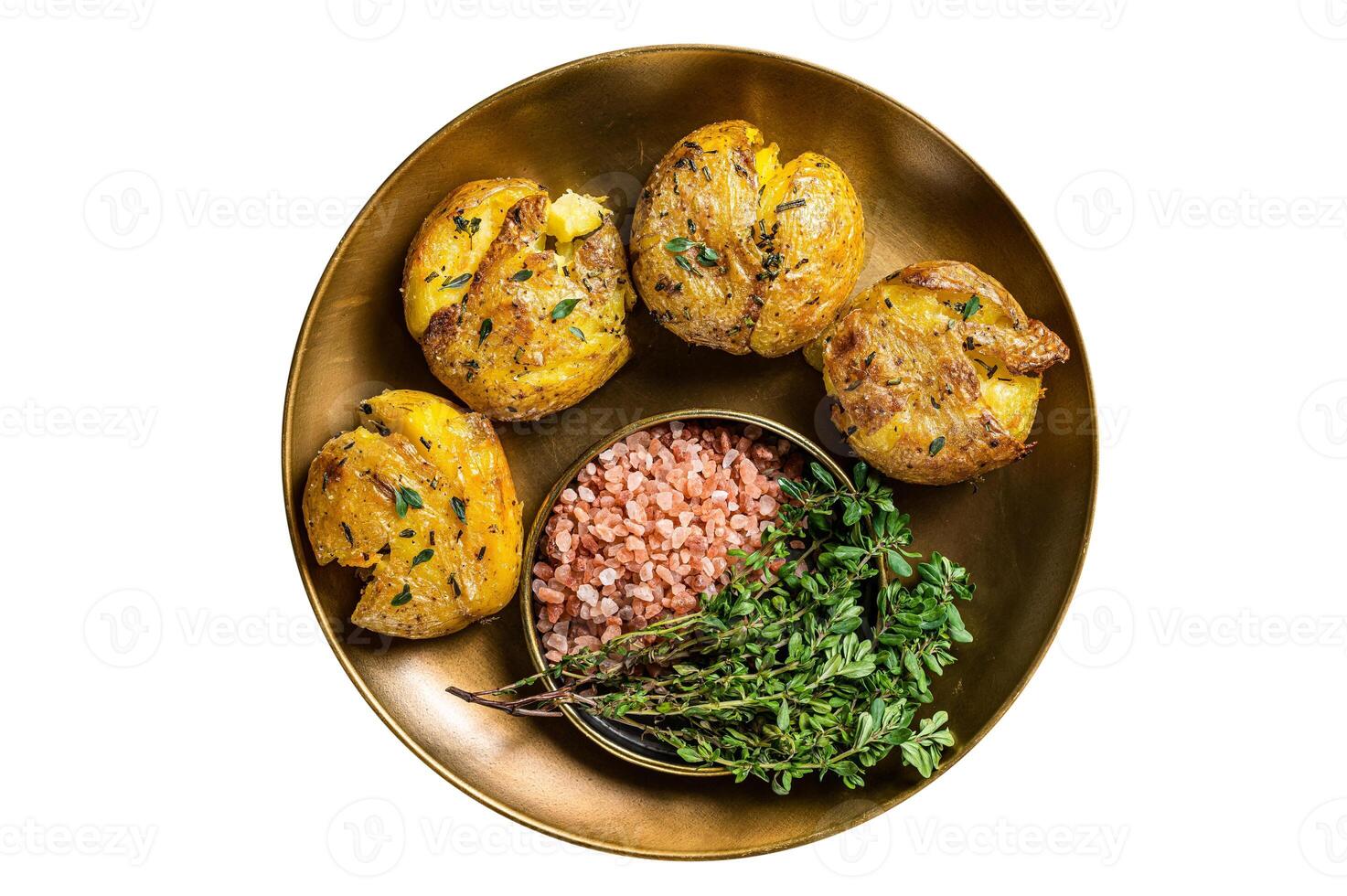 Crushed, smashed potatoes baked with rosemary and thyme on plate. Isolated on white background. photo