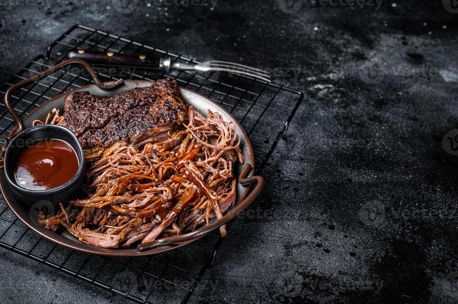 Slow Cooked Pulled Beef, Traditional meat rubbed with spices and smoked in a Texas smoker. Black background. Top view. Copy space photo