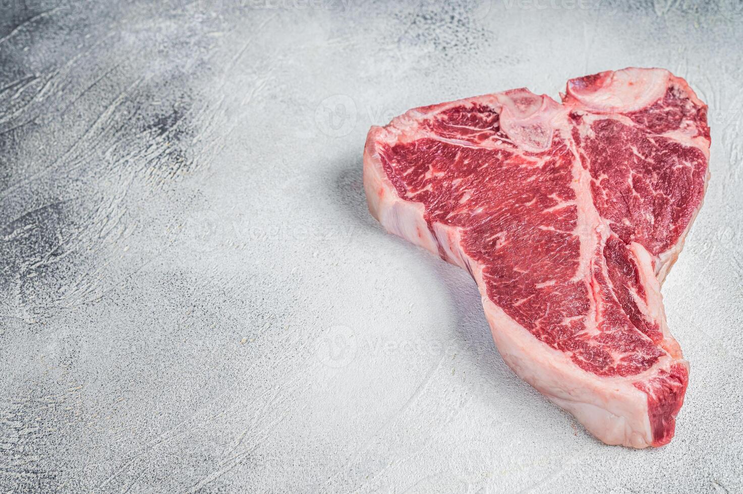 Porterhouse T-bone raw beef meat Steak. White background. Top view. Copy space photo