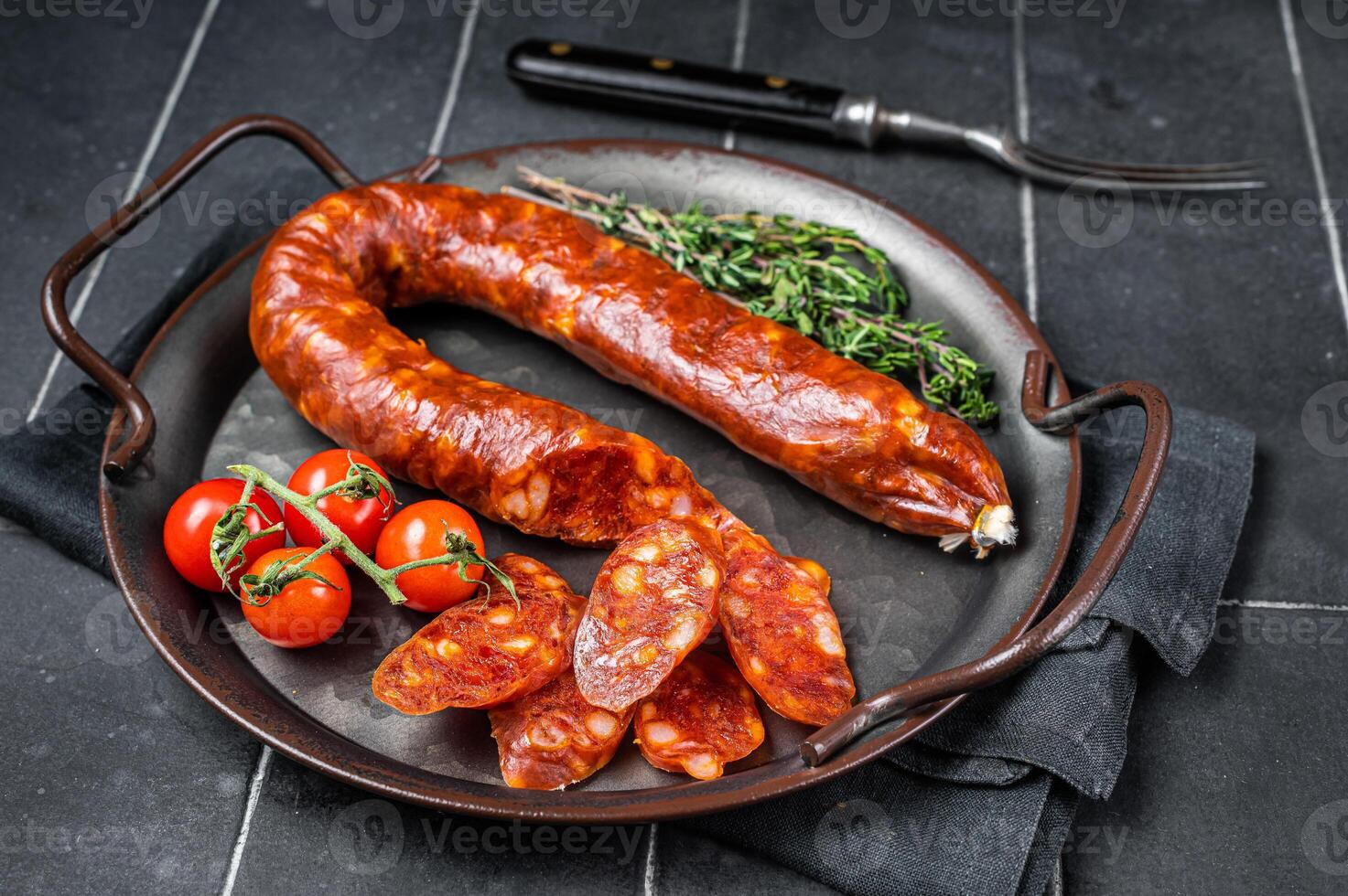 Sliced Chorizo sausage, slices of dry cured pork with herbs and spices. Black background. Top view photo