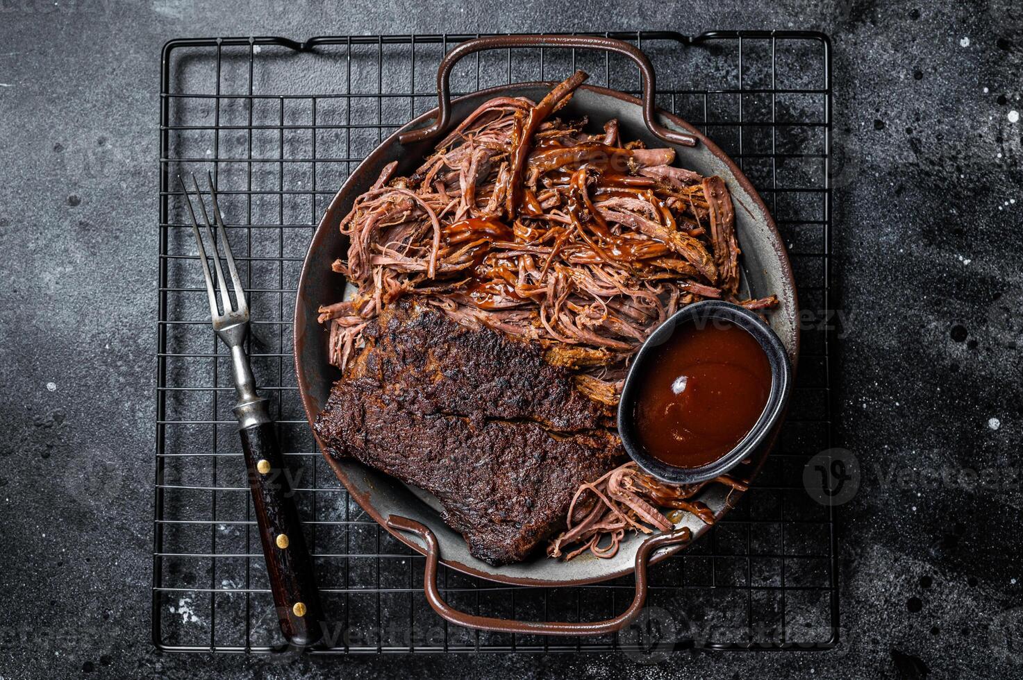Slow Cooked Pulled Beef, Traditional meat rubbed with spices and smoked in a Texas smoker. Black background. Top view photo