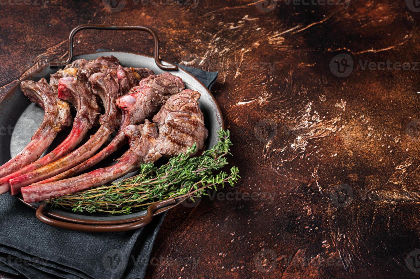 BBQ Grilled lamb chop steak, mutton rib cutlet in steel tray with thyme. Dark background. Top view. Copy space photo
