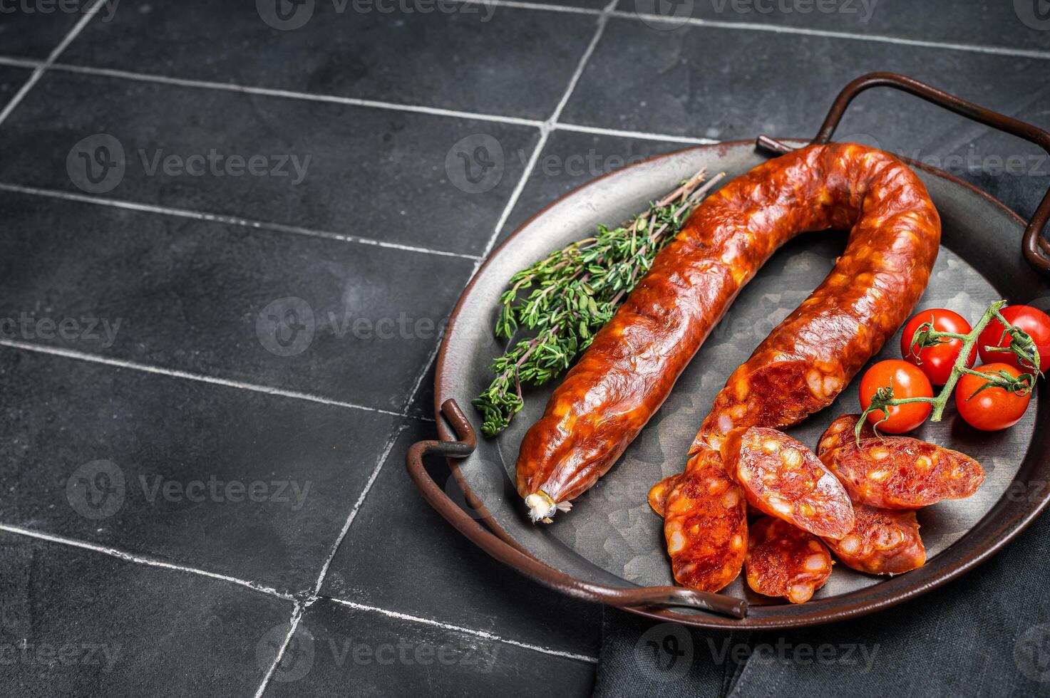Sliced Chorizo sausage, slices of dry cured pork with herbs and spices. Black background. Top view. Copy space photo