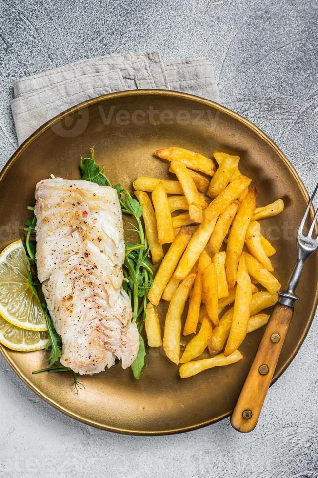 Fried cod fish fillet served with french fries. White background. Top view photo