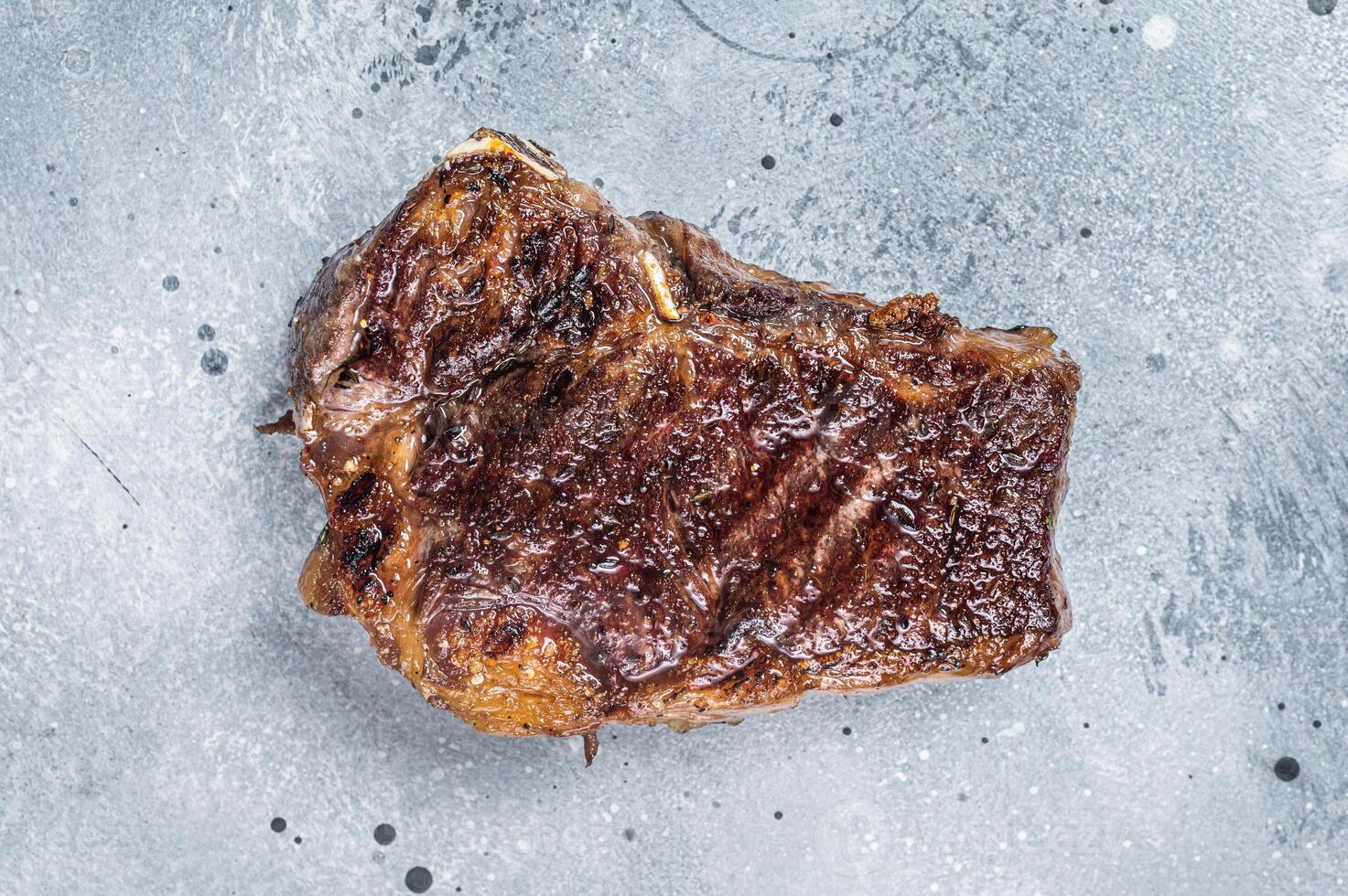 Grilled Striploin beef meat steak or new york steak. Gray background. Top view. Copy space photo