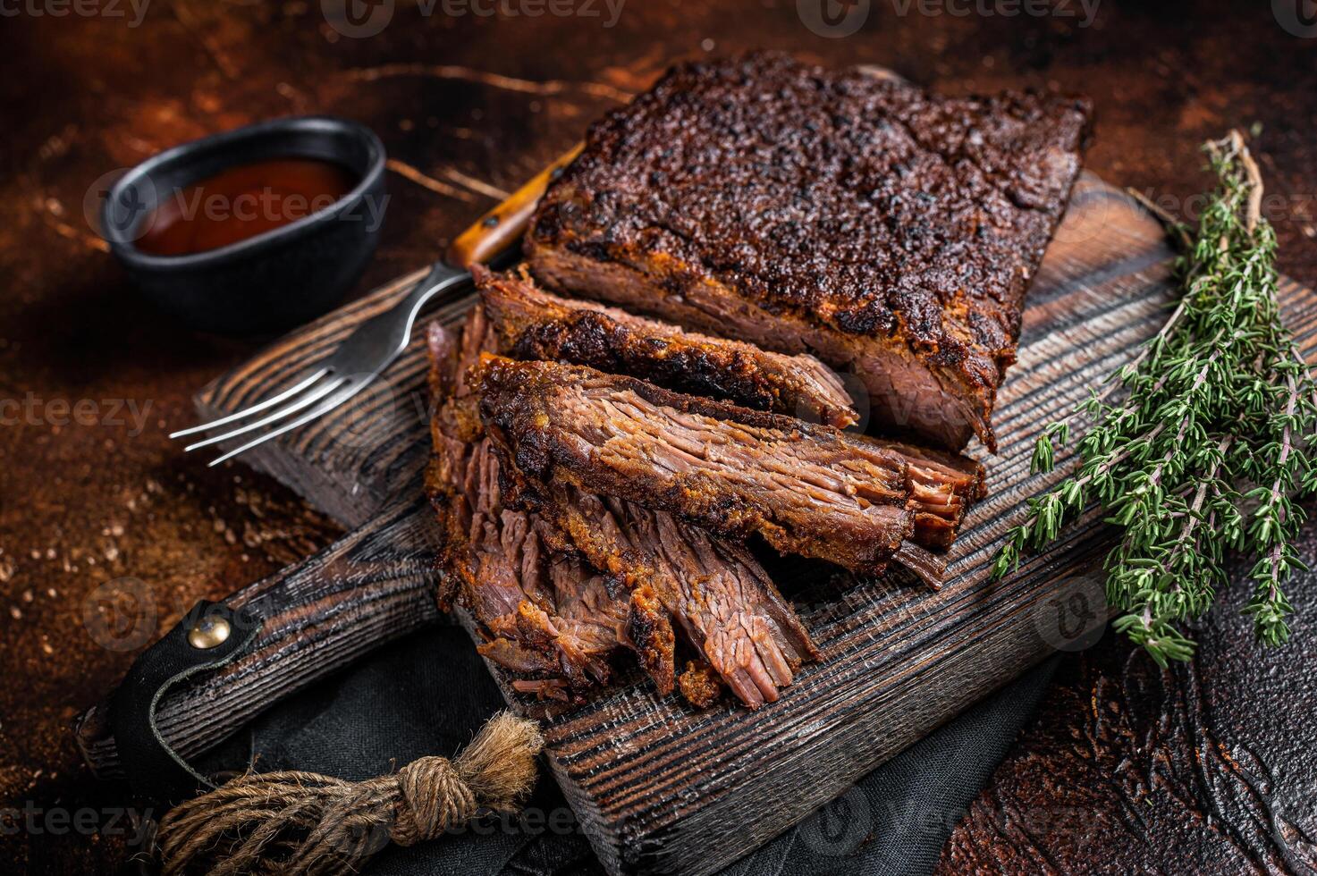 Traditional smoked barbecue wagyu beef brisket on wooden board. Dark background. Top view photo