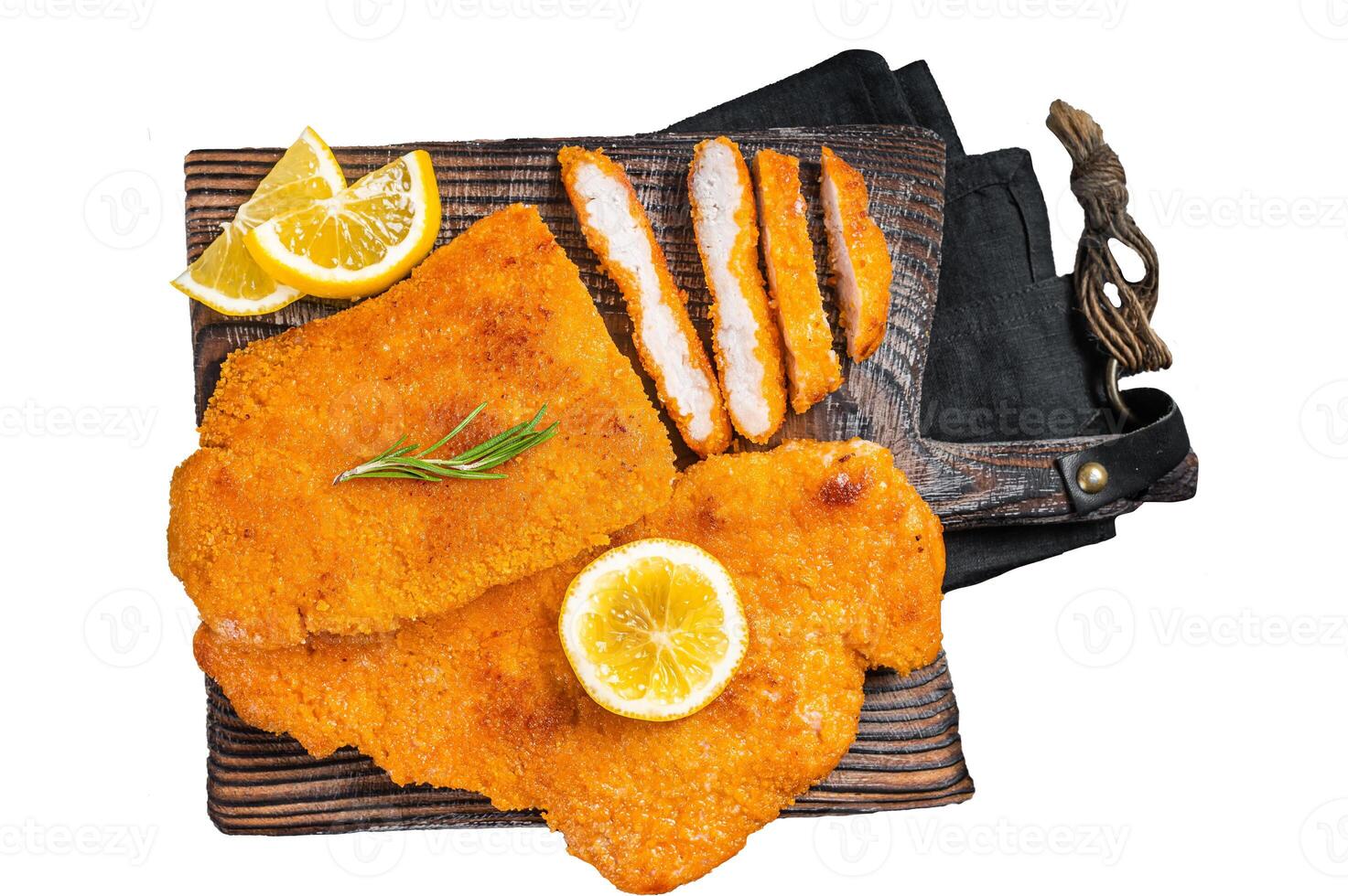 Fried sliced weiner schnitzel on a wooden board with herbs. Isolated, white background. photo