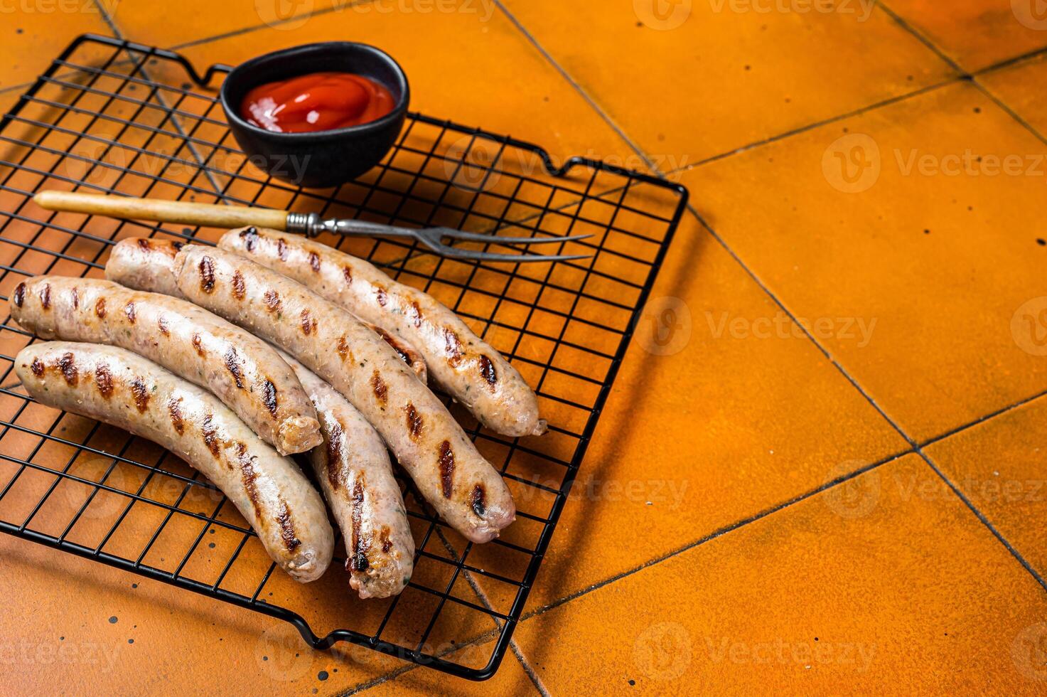 Grilled pork sausages from a BBQ. Orange background. Top view. Copy space photo