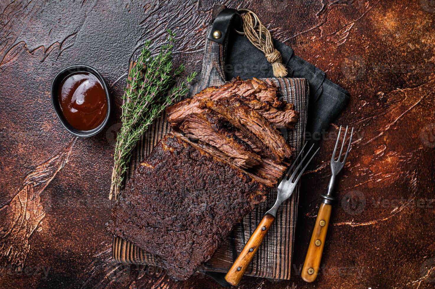 Traditional smoked barbecue wagyu beef brisket on wooden board. Dark background. Top view photo
